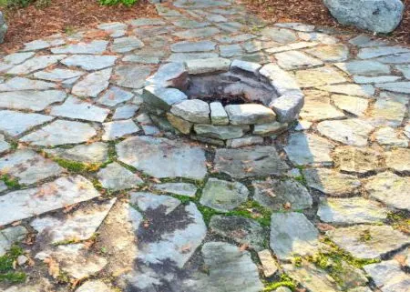 Rustic flagstone patio with a natural stone fire pit and irregular stone paving